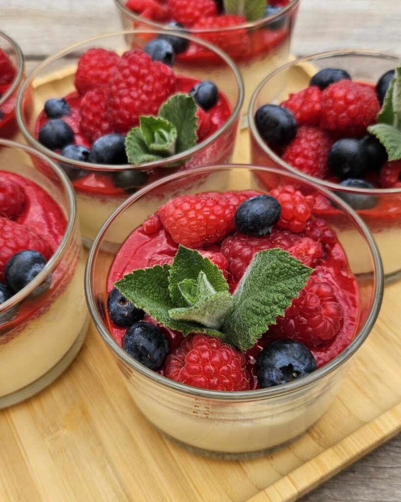 Panna cotta crémeuse garnie de fruits rouges frais et de myrtilles.