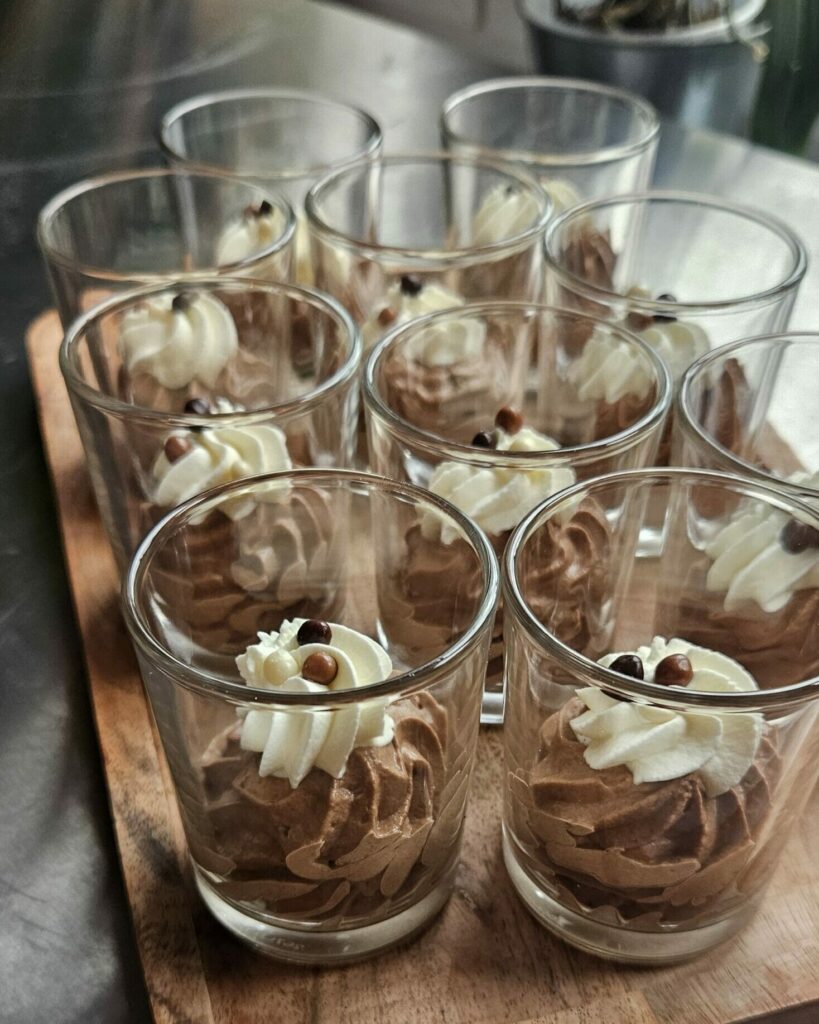 Plateau de verrines individuelles de mousse au cacao, décorées de chantilly et billes croquantes