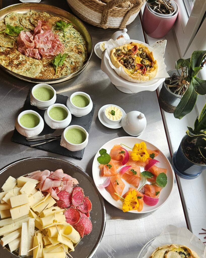 Buffet brunch avec omelettes aux herbes, petits pains variés, saumon fumé, plateau de fromages et charcuterie, quiches, verrines et sauces maison.