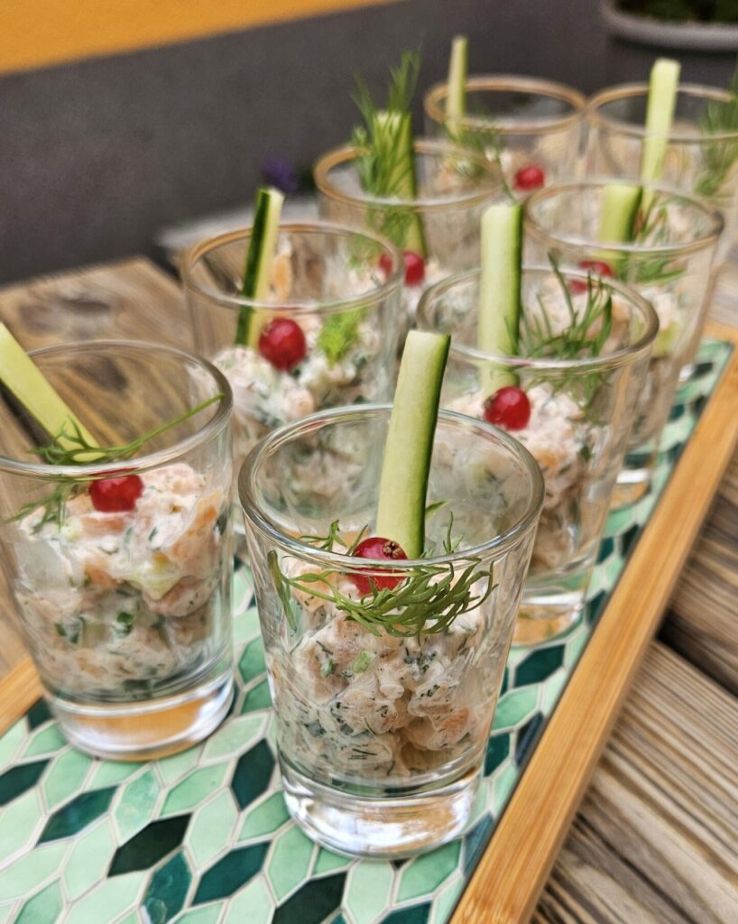 Verrine apéritive de saumon frais à l’aneth, garnie de concombre croquant et décorée de groseille rouge.